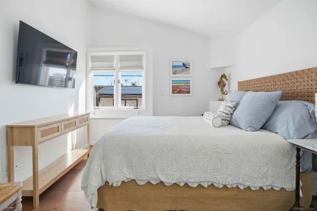 a bedroom with a large bed and a flat screen tv