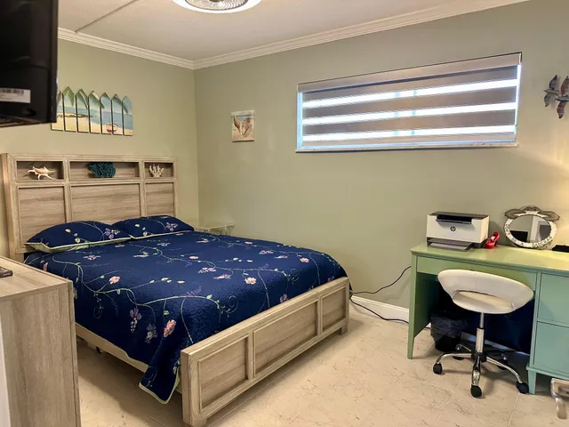 a living room with a bed and a flat screen tv