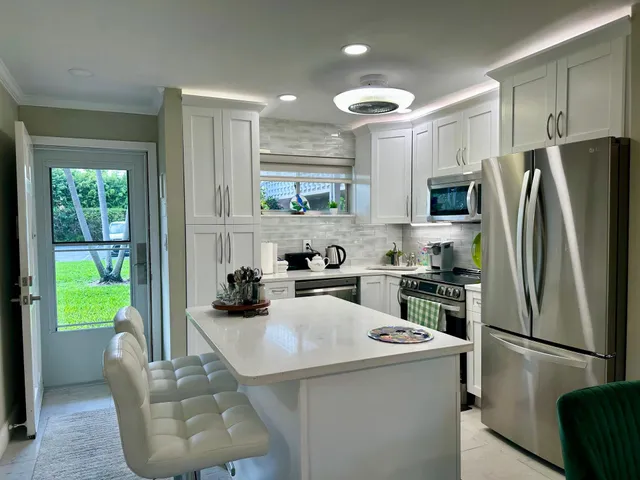 a kitchen with stainless steel appliances a refrigerator a stove a sink and a refrigerator