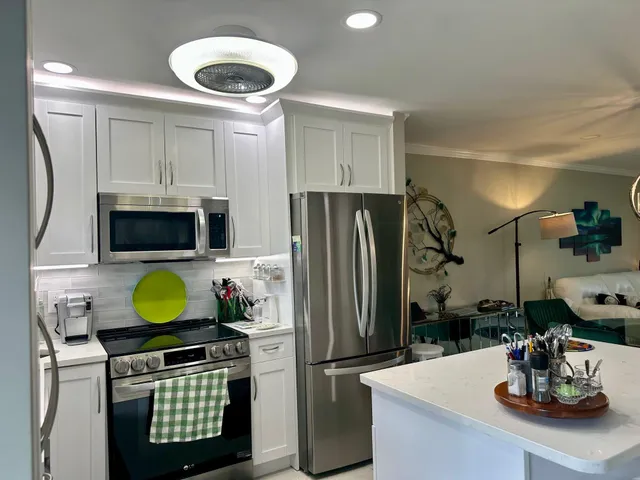 a kitchen with a refrigerator a microwave a sink and a dining table