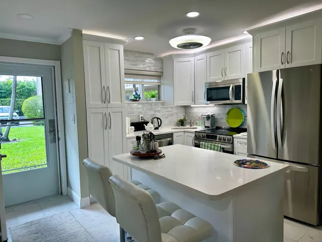 a kitchen with a sink a refrigerator and a stove top oven