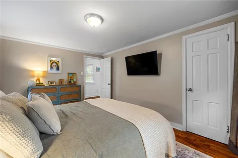 a bedroom with a bed and a flat tv screen on dresser