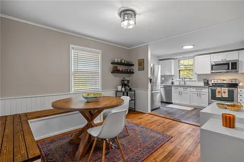 a kitchen with granite countertop kitchen island stainless steel appliances a stove a table and a refrigerator