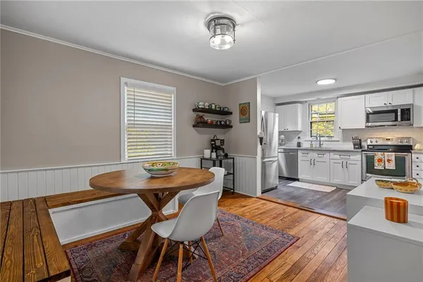 a kitchen with granite countertop kitchen island stainless steel appliances a stove a table and a refrigerator