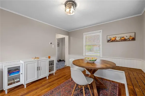 a view of a dining room with furniture a chandelier and wooden floor