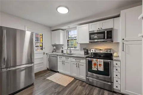 a kitchen with a stove refrigerator and microwave