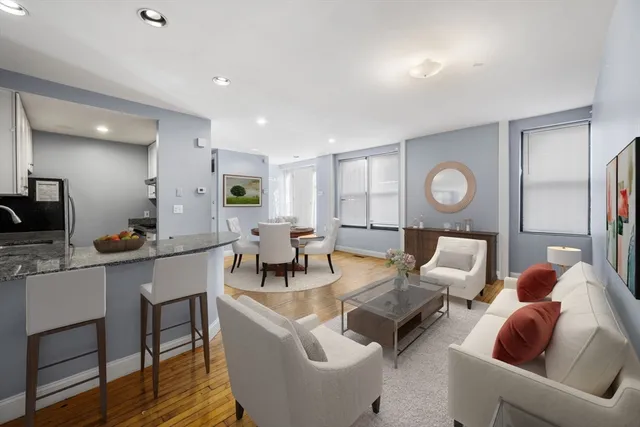 a living room with furniture kitchen view and a window