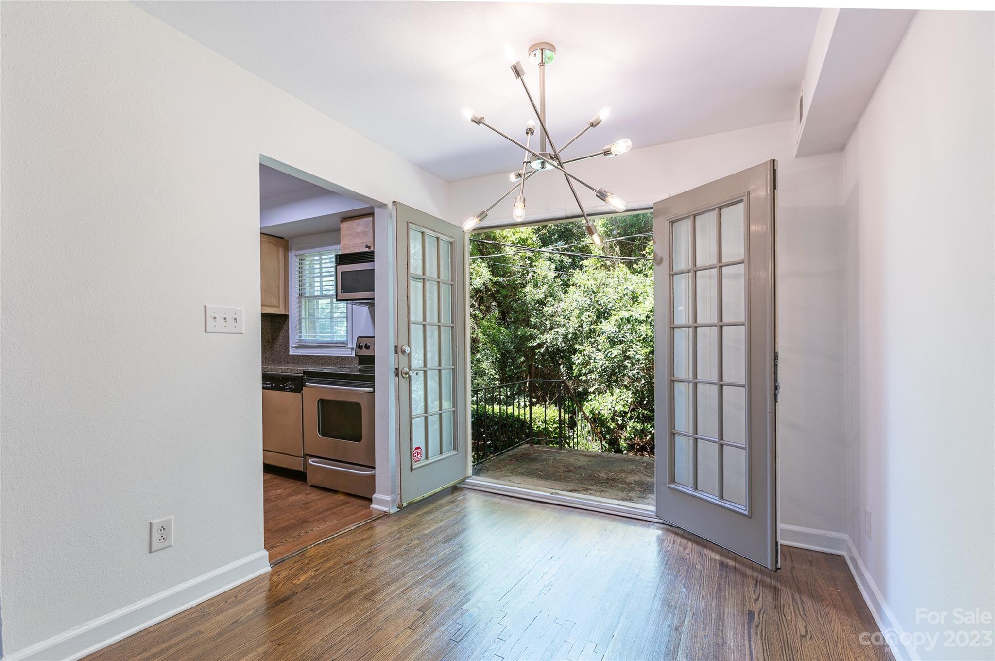 4319 Walker Road, Unit C Charlotte, NC 28211 - Photo 5 of 13 a view of a livingroom with wooden floor a ceiling fan and windows