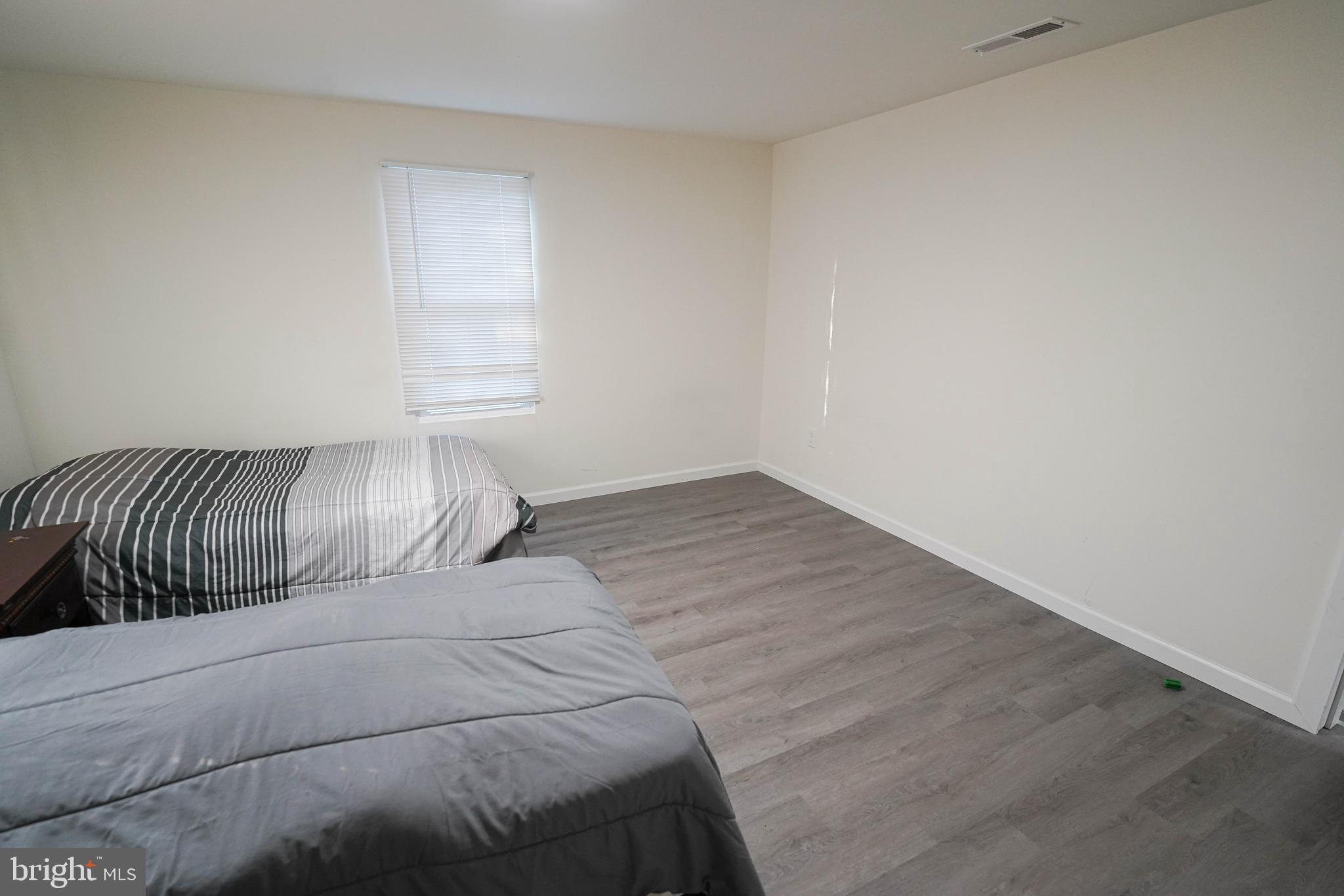 231 Newton Street, Unit B Salisbury, MD 21801 - Photo 23 of 31 a bed sitting in a bedroom next to a window