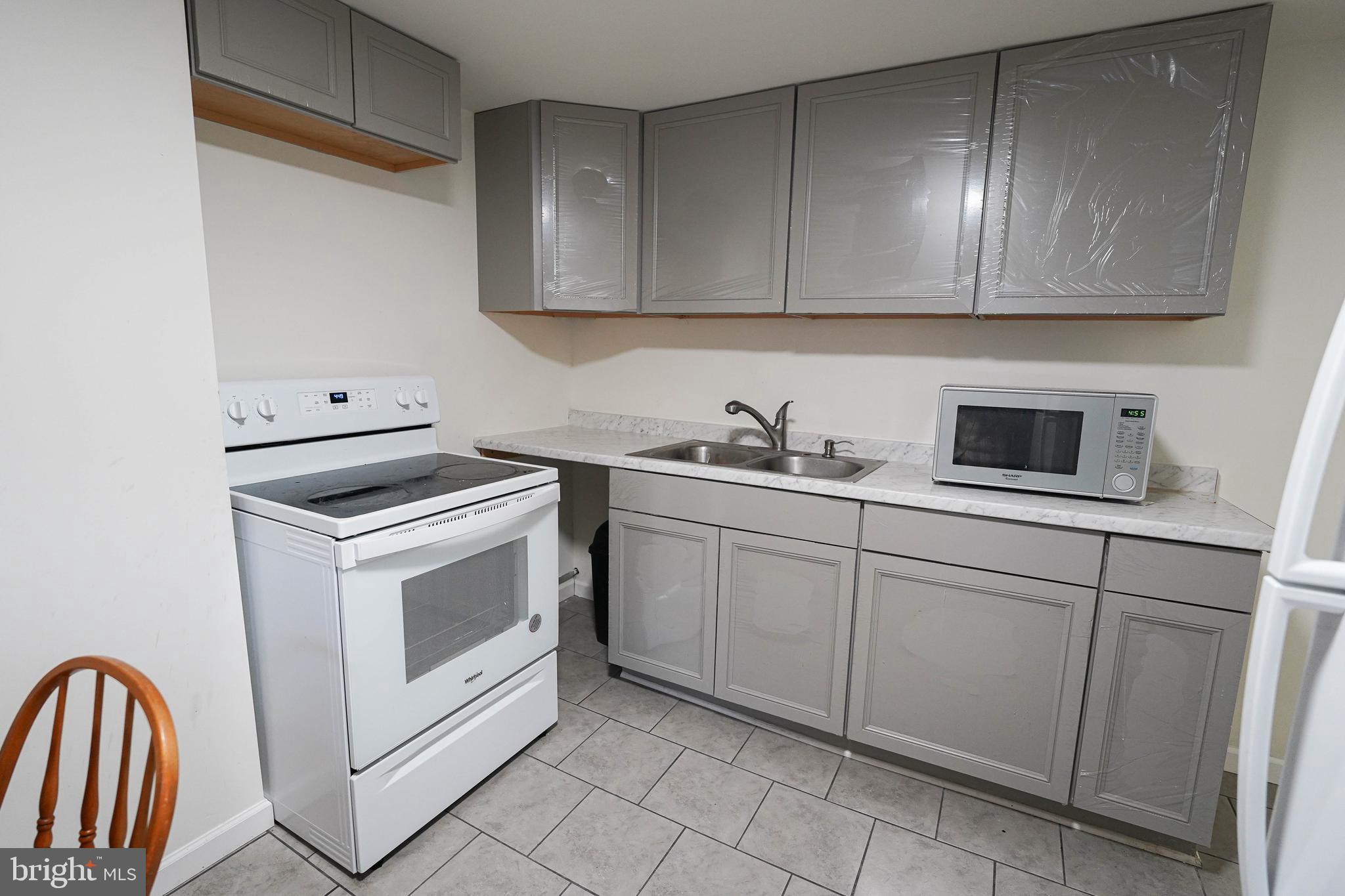 231 Newton Street, Unit B Salisbury, MD 21801 - Photo 26 of 31 a kitchen with white cabinets stainless steel appliances and sink