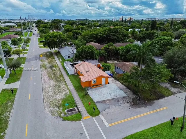 an aerial view of a house with a yard and lake view