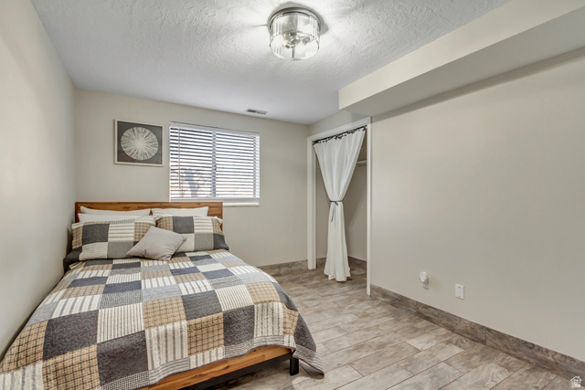 933 South Freedom Boulevard, Unit 7 Provo, UT 84601 - Photo 20 of 23 Bedroom featuring light wood-type flooring, a closet, and a textured ceiling