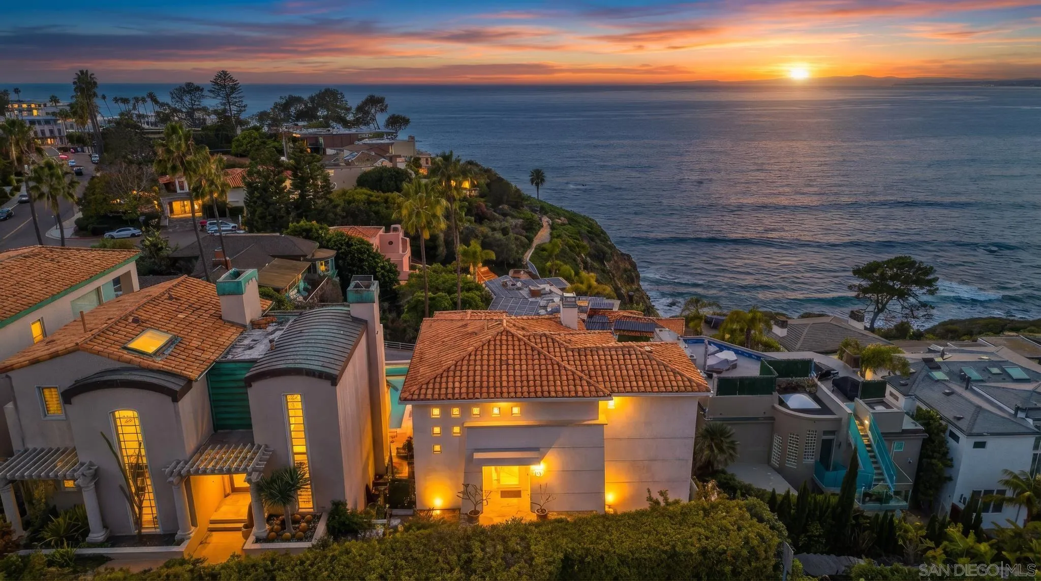 a view of a city with lots of residential buildings ocean and mountain view in back