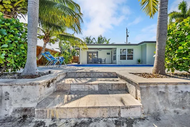 a front view of a house with a yard and potted plants