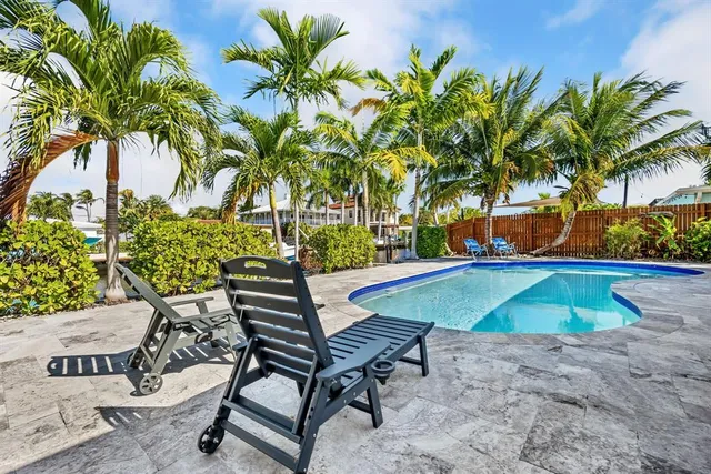 a backyard of a house with table and chairs under an umbrella