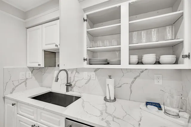 a kitchen with a sink and a stove with cabinets