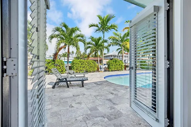 a view of a porch with chairs and potted plants