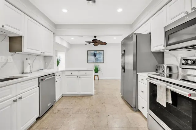 a kitchen with white cabinets and stainless steel appliances