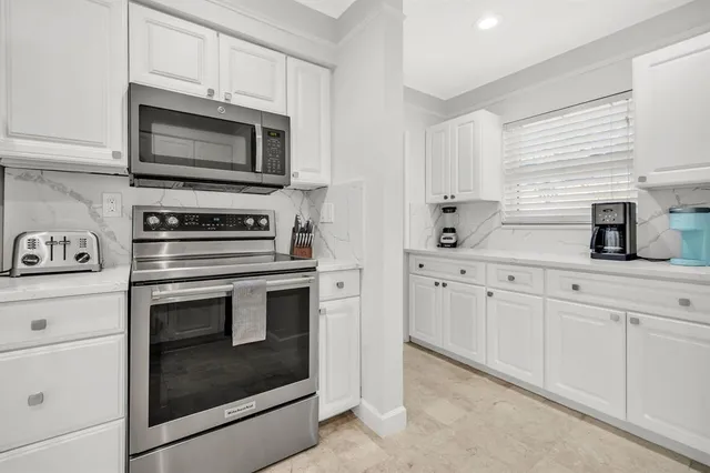 a kitchen with white cabinets stainless steel appliances and sink