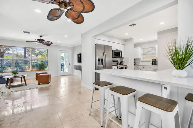 a kitchen with a dining table chairs sink and white cabinets