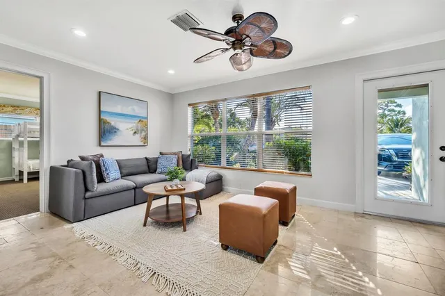 a living room with furniture ceiling fan and a large window