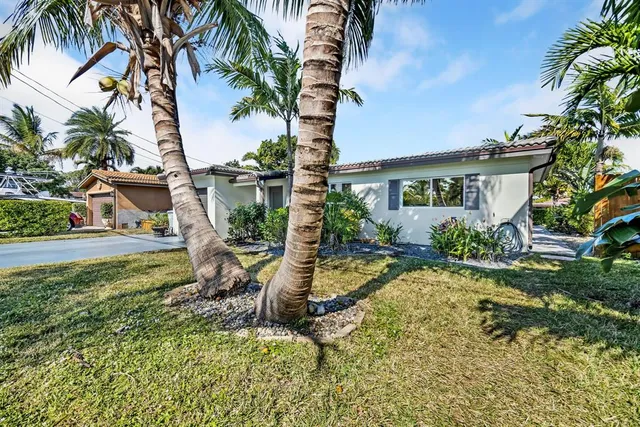 a view of a house with backyard and sitting area