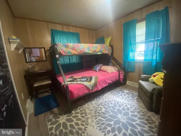 a bedroom with a bed and a lamp on dresser