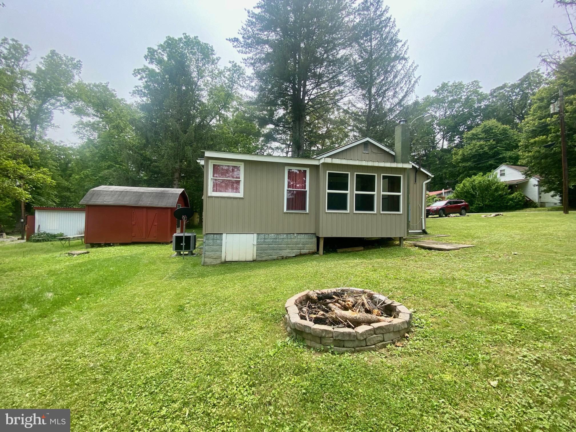 3815 Capon River Road Yellow Spring, WV 26865 - Photo 21 of 21 a view of a wooden house with a yard and large trees