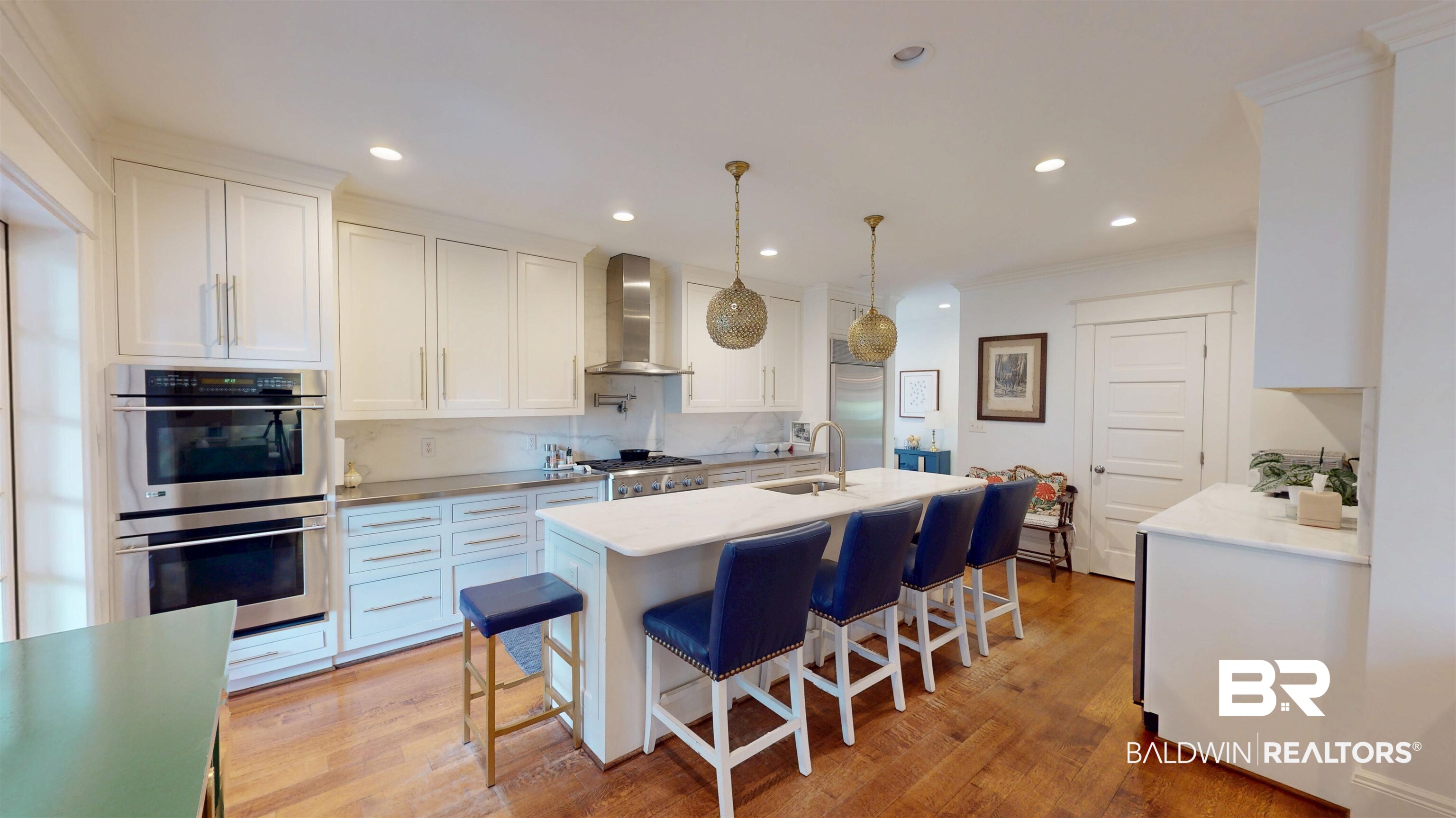 211 Lanier Avenue Mobile, AL 36607 - Photo 20 of 73 Kitchen featuring ornamental molding, stainless steel appliances, light wood finished floors, white cabinets, and a center island with sink