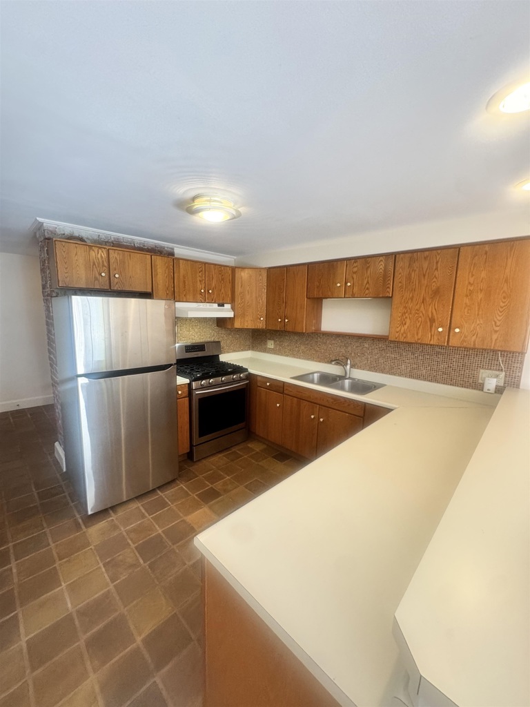 1723 Carleton Street Berkeley, CA 94703 - Photo 15 of 32 a kitchen with stainless steel appliances granite countertop a refrigerator a sink a stove and white cabinets