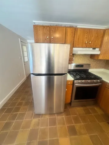 a kitchen with granite countertop a refrigerator and a stove