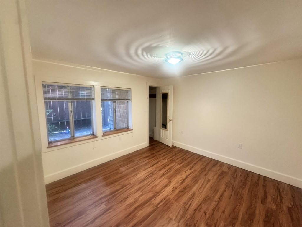 1723 Carleton Street Berkeley, CA 94703 - Photo 22 of 32 a view of an empty room with wooden floor and a window
