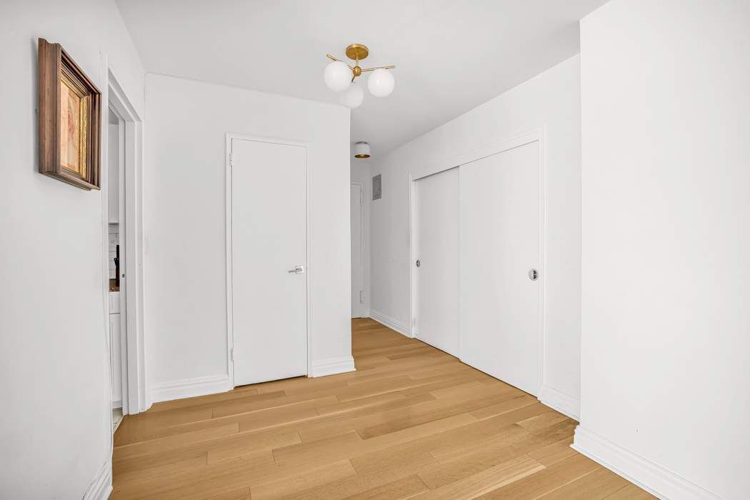 205 West End Avenue, Unit 2J Manhattan, NY 10023 - Photo 2 of 10 a view of a big room with closet and a chandelier fan