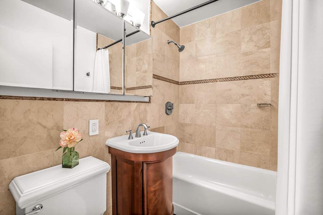 205 West End Avenue, Unit 2J Manhattan, NY 10023 - Photo 9 of 10 a bathroom with a sink and a bathtub with shower
