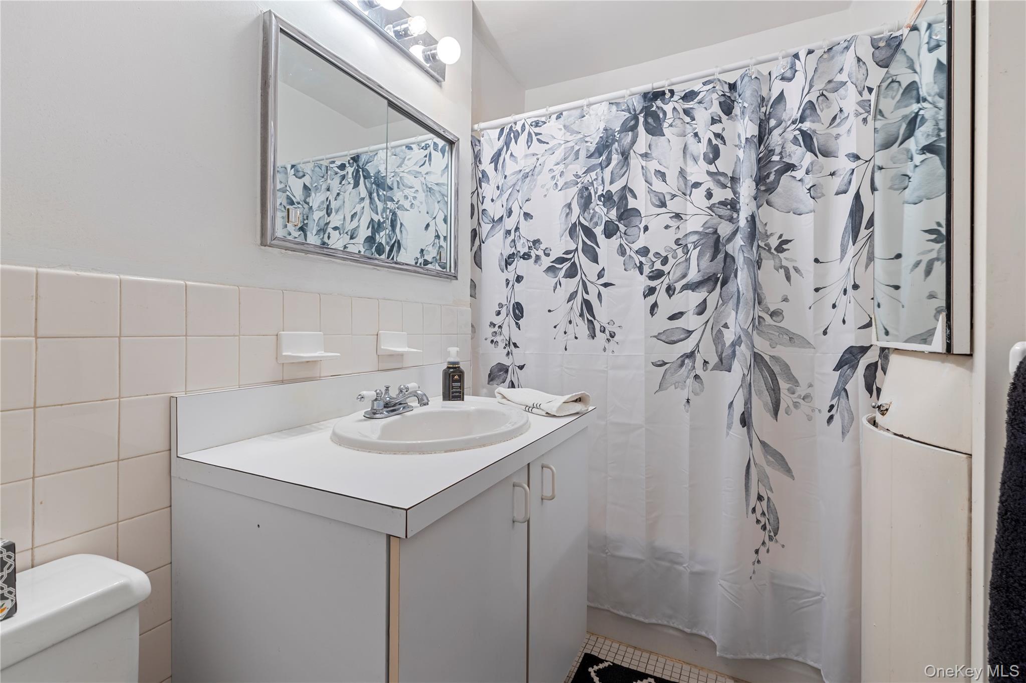 711 Shore Road, Unit 3B Long Beach, NY 11561 - Photo 11 of 20 Bathroom with tile walls, vanity, and shower / bath combo with shower curtain