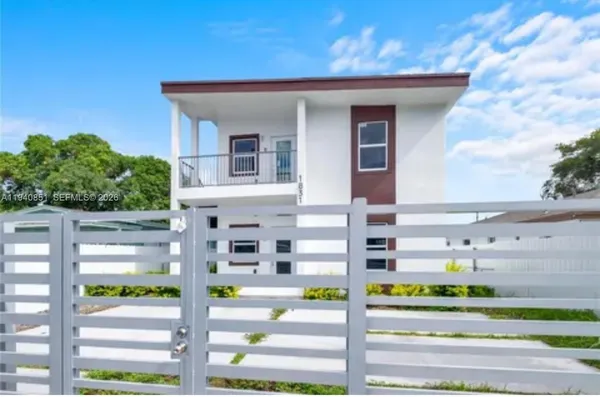 a front view of a building with a garden and plants
