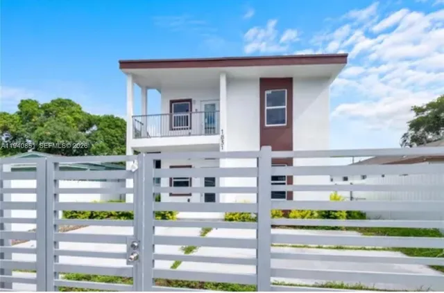 a front view of a building with a garden and plants