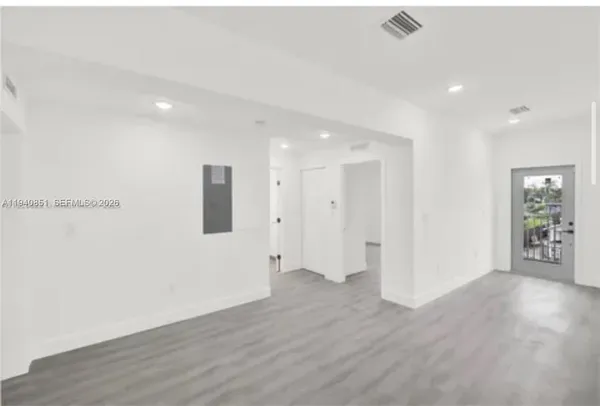 a view of empty room with wooden floor