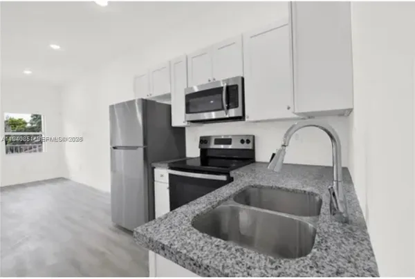 a kitchen with stainless steel appliances white cabinets and a refrigerator