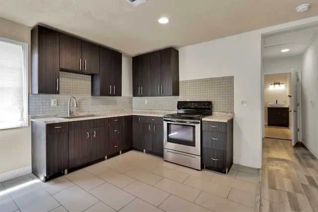 a kitchen with stainless steel appliances a stove sink and cabinets