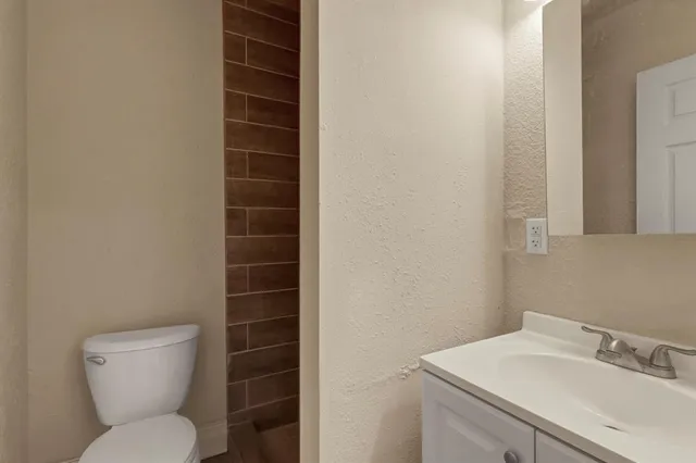 a bathroom with a toilet a sink and a window