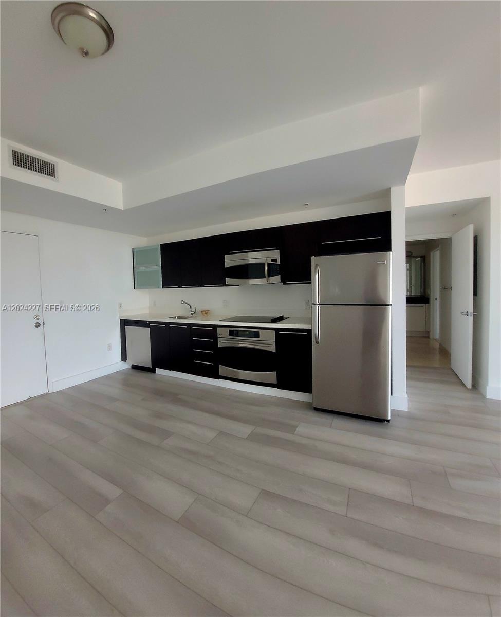 90 Southwest 3rd Street, Unit 2208 Miami, FL 33130 - Photo 10 of 56 a kitchen with stainless steel appliances a refrigerator and a stove