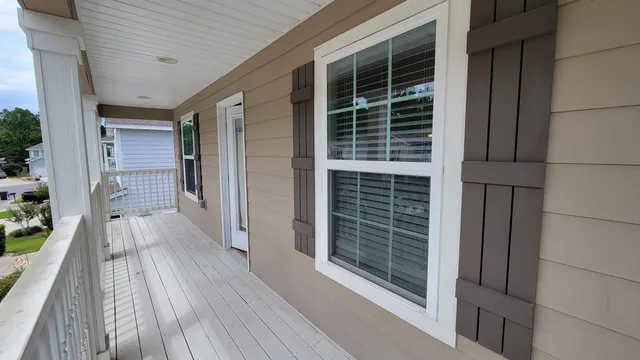 a view of a balcony with wooden floor and fence
