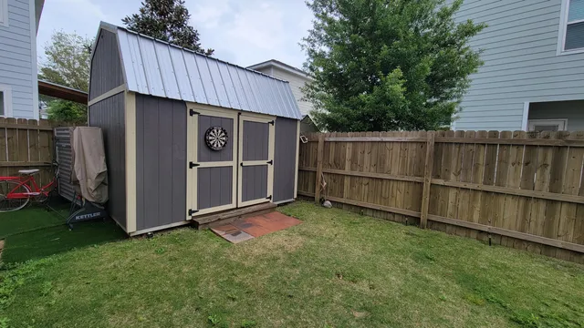 a view of backyard with wooden fence