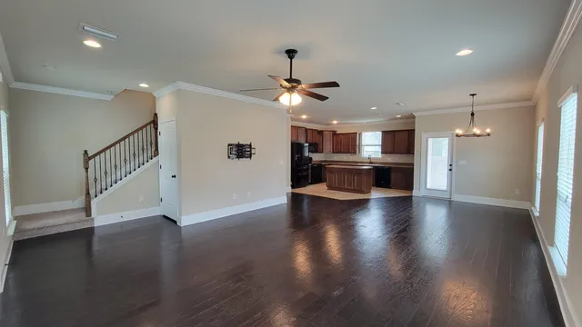 a view of a hallway with wooden floor and a kitchen