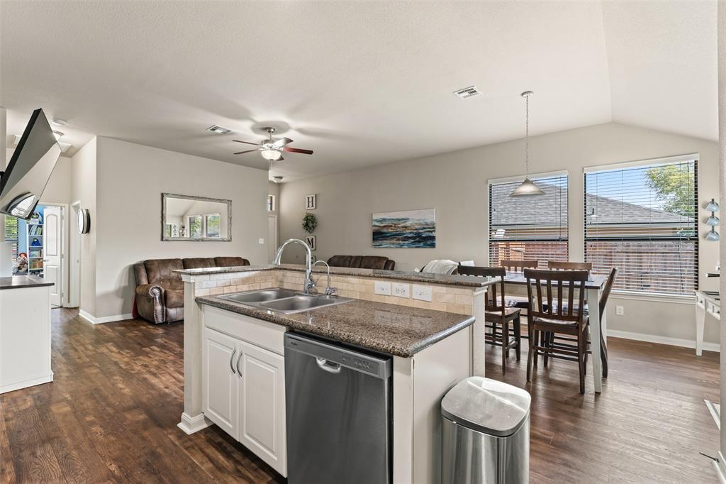10313 Condor Loop Waco, TX 76708 - Photo 19 of 33 Kitchen island with double basin sink, stainless steel dishwasher, and granite countertop