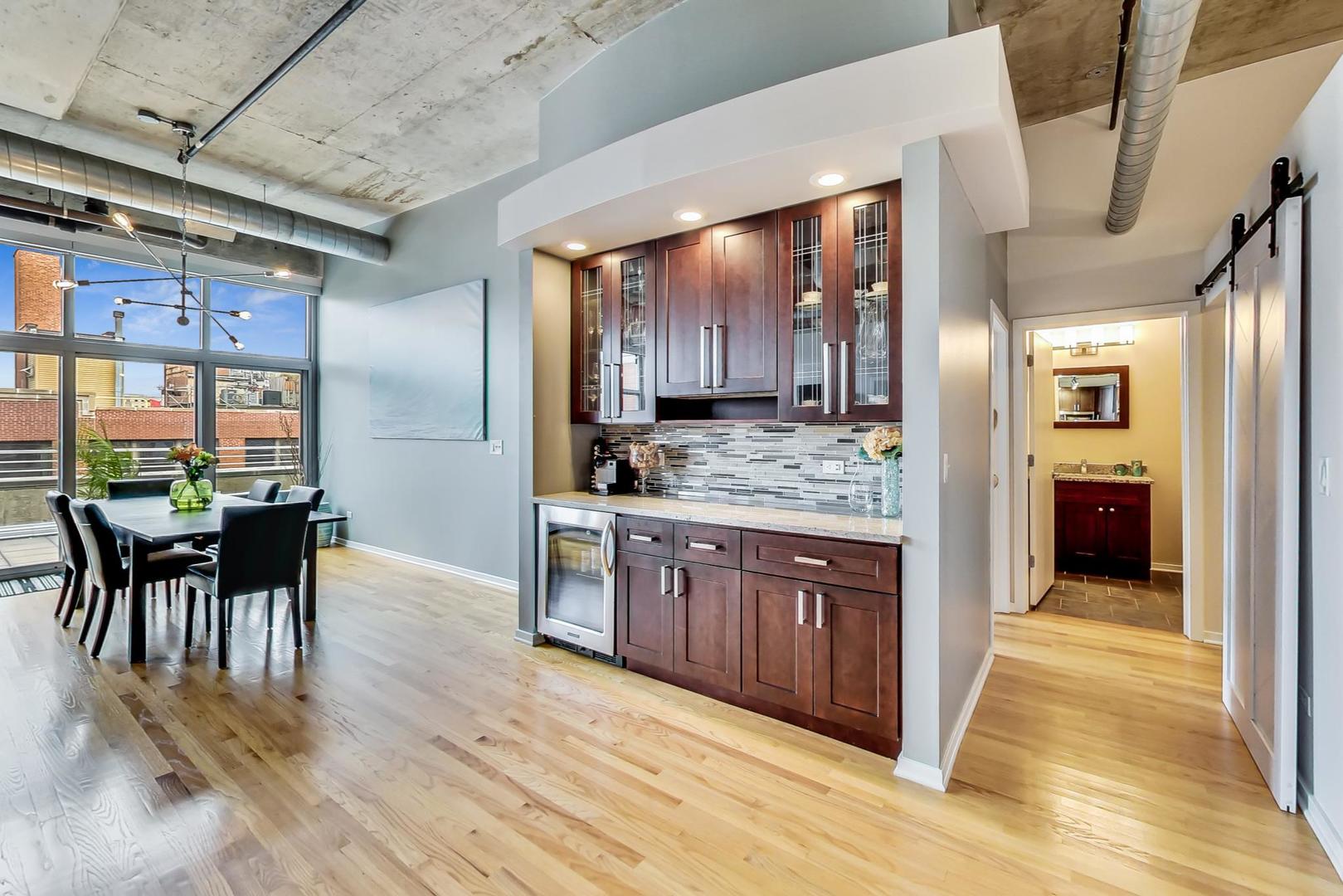933 West Van Buren Street, Unit 903 Chicago, IL 60607 - Photo 16 of 50 a kitchen with stainless steel appliances granite countertop wooden floors and wooden cabinets