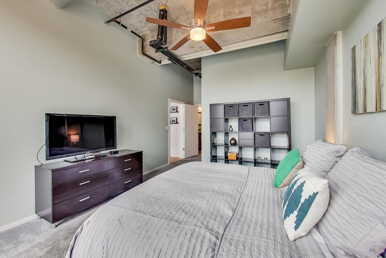 933 West Van Buren Street, Unit 903 Chicago, IL 60607 - Photo 24 of 50 a bedroom with a bed and a flat screen tv