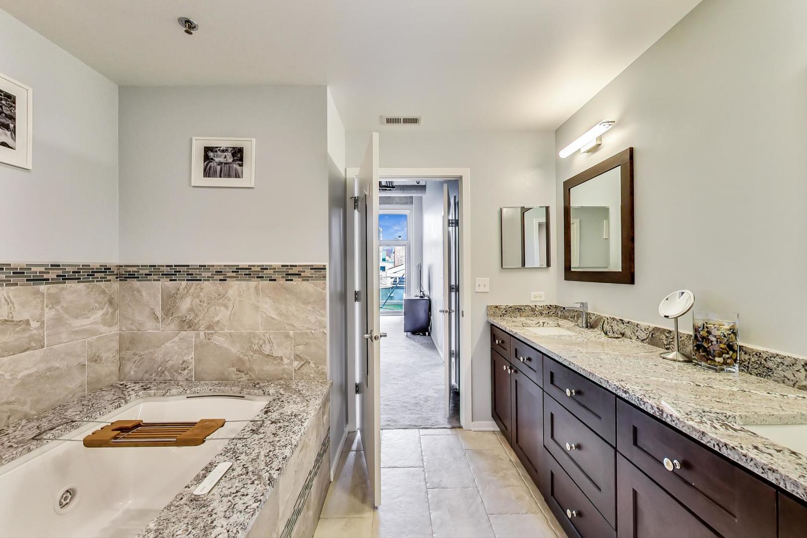933 West Van Buren Street, Unit 903 Chicago, IL 60607 - Photo 27 of 50 a bathroom with a tub sink and mirror