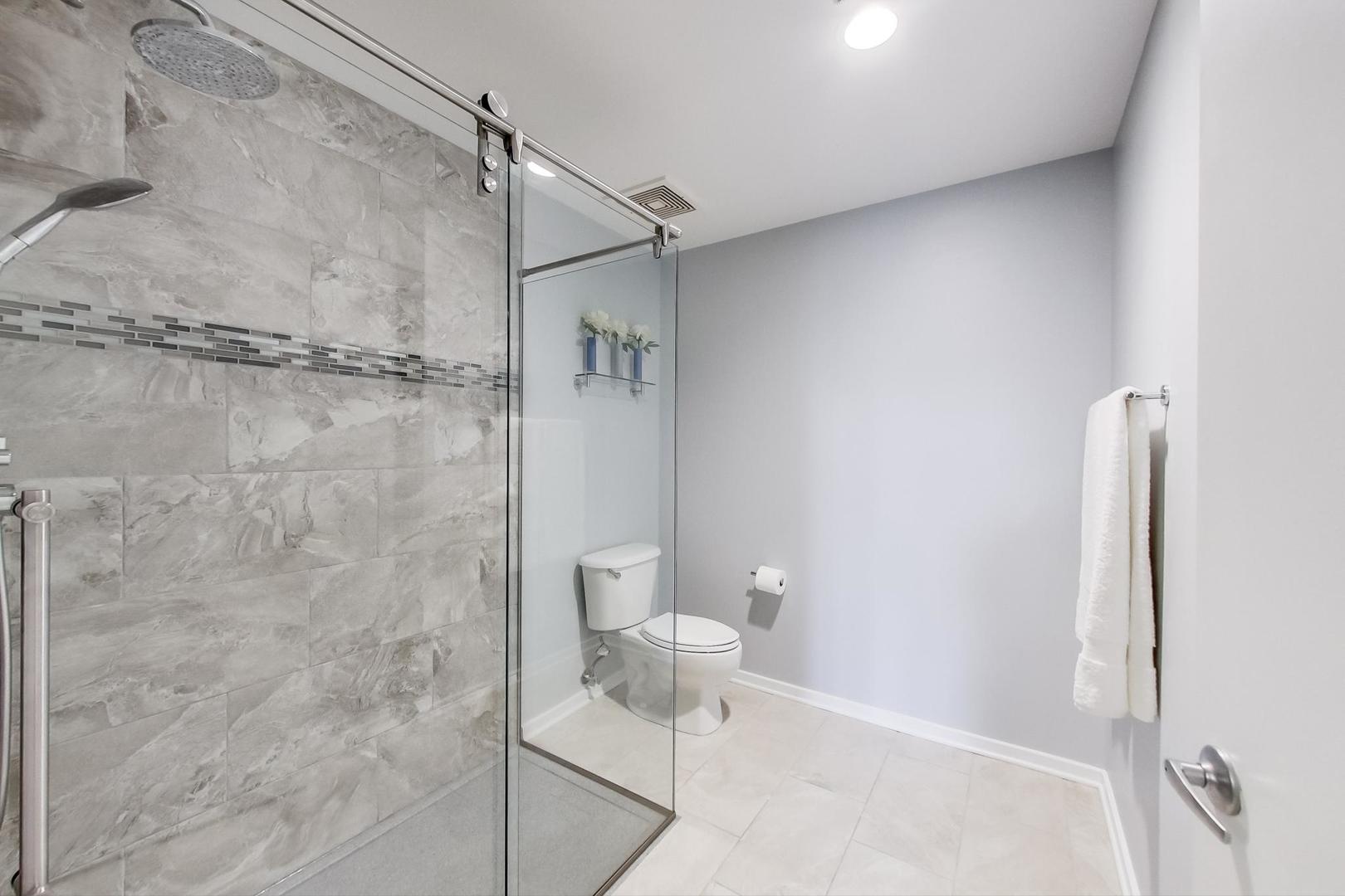 933 West Van Buren Street, Unit 903 Chicago, IL 60607 - Photo 28 of 50 a bathroom with a shower and toilet